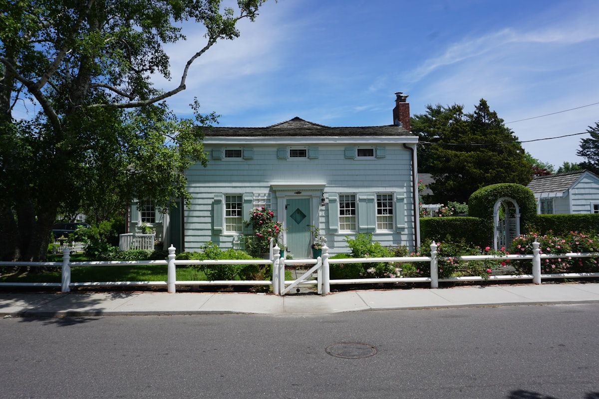 A bayside Hampton driveway entrance with a narrow front setback, fencing along the boundary, and a gate opening beside a sloping driveway, showing how the available space and site layout determine whether a sliding or swing gate would fit